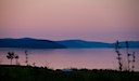 Kvällsvy mot Mjältön från stranden nedanför stugorna